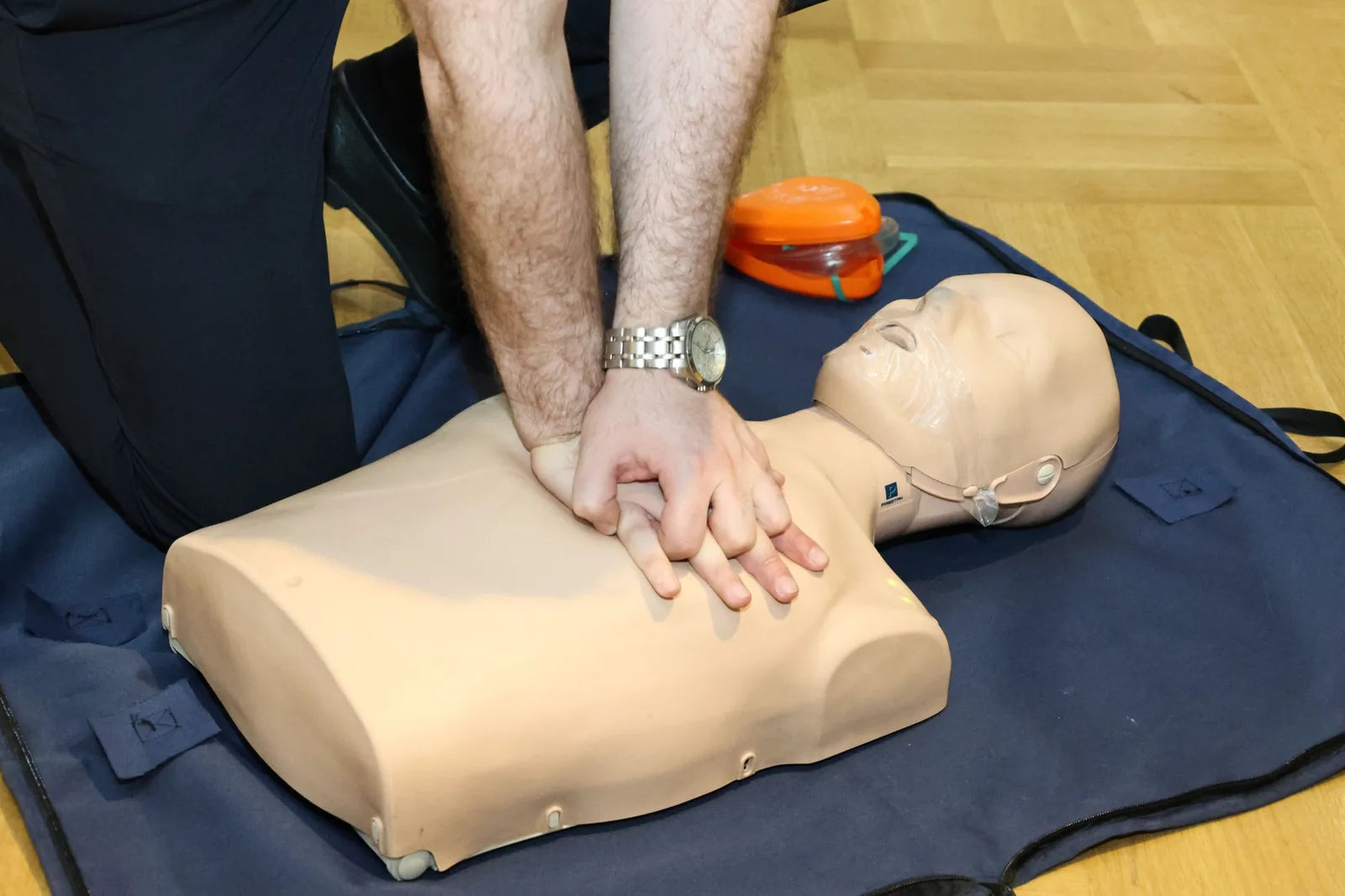 Chest compressions being practised on a CPR manikin during first-aid training